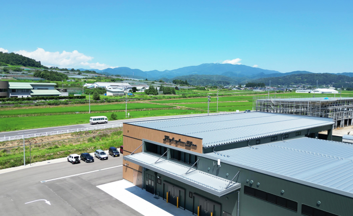 緑豊かな山々と青空に囲まれた、アイ・イー・シーの山形工場外観