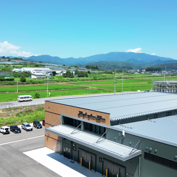 青空と緑豊かな山々に囲まれた、アイ・イー・シーの山形工場外観