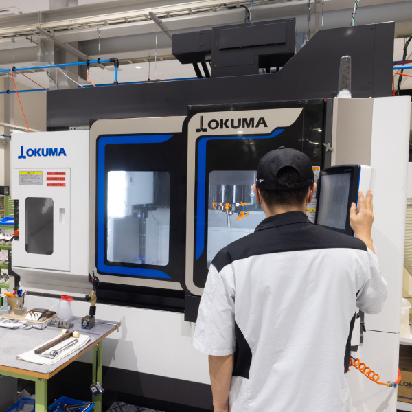 多数の工作機械が整然と並ぶ、白を基調とした清潔で明るい工場内の様子